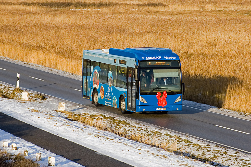 Am 9. Dezember 2010 rollte der NF-SV 838 am Biikeplatz von Westerland vorbei, als der Bus auf der Stadtbuslinie A unterwegs war. Die rote Schleife am Bus ist ein Weihnachtsgru der SVG