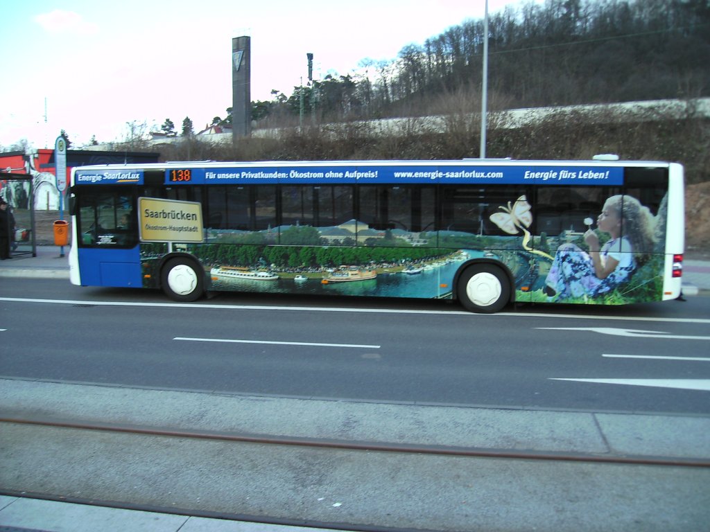 Ein MAN-Lions City der Firma Bur-Reisen die im Auftrag fr Saarbahn und Bus fhrt am Rmerkastel in Saarbrcken. Die Aufnahme des Fotos war am 05.03.2010. Auf dem Bus ist Werbung eines Saarbrcker-Energie Unternehmens zu sehen. Dieses Foto zeigt Werbung mit einem Panorama aus Saarbrcken.