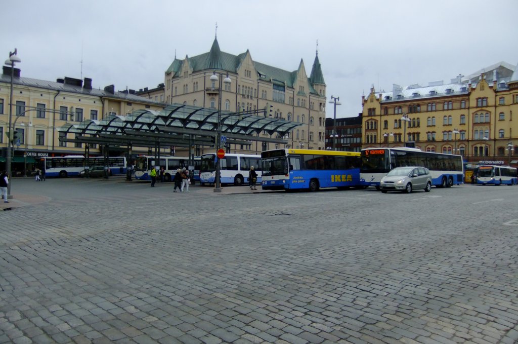 Heimatschutz auf Finnisch: Der Busbahnhof von Tampere ist direkt auf den grossen Hauptplatz der Stadt gebaut worden. Zentraler geht's wohl nicht mehr. Das Bild vom 18.6.2010 zeigt einen schnen Querschnitt durch die Stadt- und Regionalbusflotte der Stadt: Volvo 8700, Scania/Carrus und ein lterer Volvo/Vest als IKEA-Bus. 