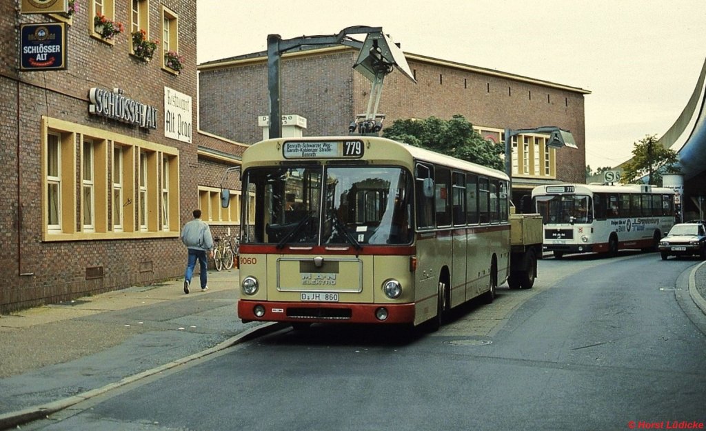 Zwischen 1975 und 1988 setzte die Rheinbahn Düsseldorf auf der Linie 39 (ab 1980 779) versuchsweise zunächst 14, später 21 Elektrobusse des Typs SL-E (Hersteller MAN/Bosch) ein, die ihre Energie aus einem mitgeführten einachsigen Anhänger bezogen. Hier Bus 9060 um 1980 an der Ladestation am Benrather Bahnhof. Bus 9063 ist als Museumsfahrzeug erhalten geblieben.