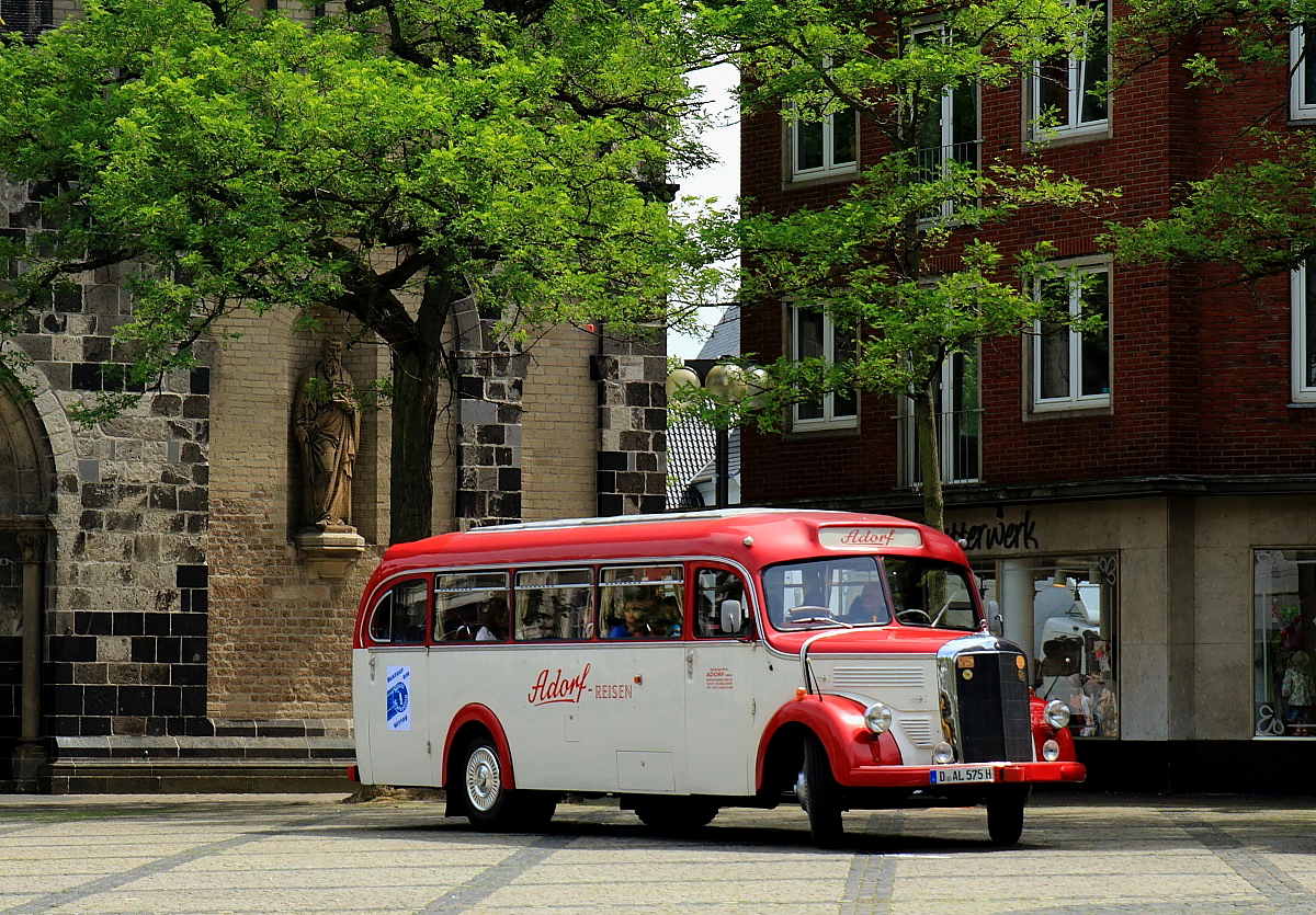 Auf dem Neusser Münsterplatz holt der Mercedes O 3500 von Adorf Reisen am 17.06.2015 eine Reisegruppe ab