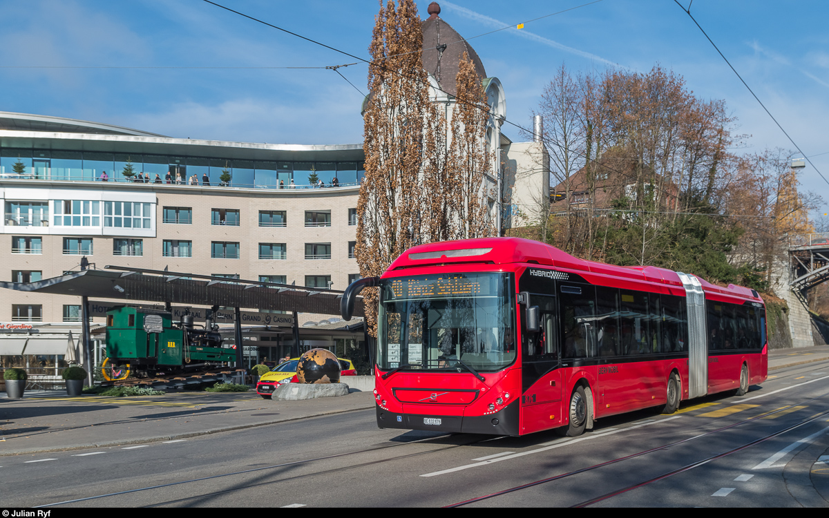 BERNMOBIL Hybridbus 876 ist am 27. November 2016 auf der Linie 10 beim Kursaal unterwegs, wo er der dort ausgestellten BRB Lok 1 begegnet.