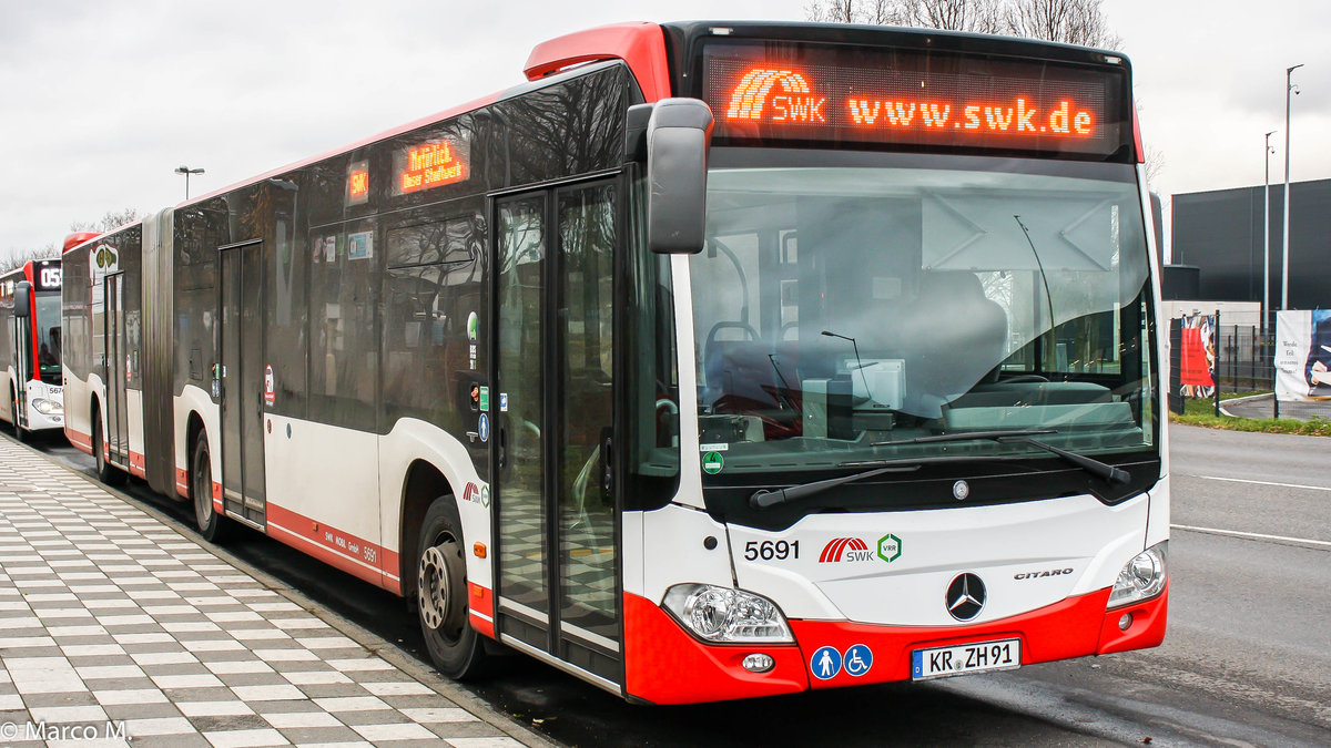 Ein Mercedes Benz O530G der 2. Generation von der SWK (Stadtwerke Krefeld) mit der Wagennummer 5691 an der Haltestelle Edelstahlwerk Tor 3. Auf der Rückseite dieses Busses, befindet sich eine „Rosinke“-Werbung. | Dezember 2018