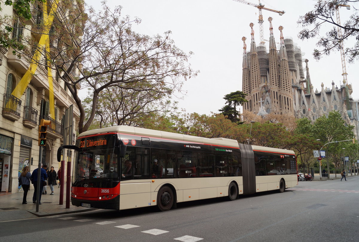 Ein Solaris Urbino 18 Hybrid der TMB (Wagen 3656, 5618-JKN) passiert auf der Fahrt nach Zona Universitària (Linie 33) den Carrer de Mallorca in Barcelona mit der Sagrada Familia im Hintergrund, 18.04.2019.