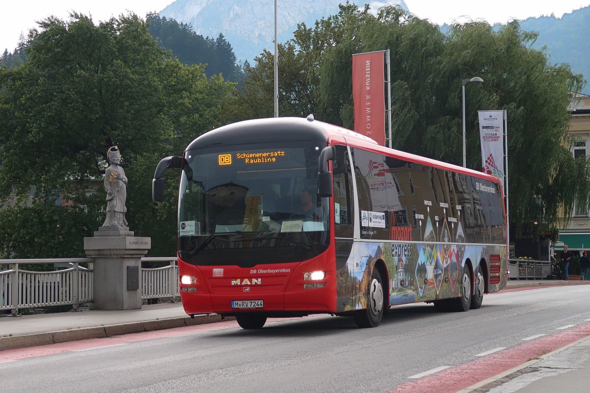 MAN Lion's Regio M-RV 7244 von DB Oberbayernbus in der Beklebung des  Mozart-Express  passiert als Schienenersatzverkehr nach Raubling die Statue des Brückenheiligen Nepomuk an der Innbrücke in Kufstein. Aufgenommen 10.8.2018.