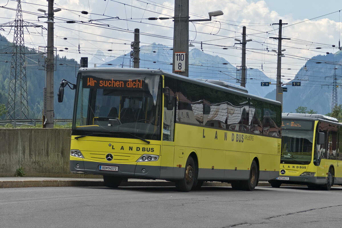 Mercedes-Benz Intouro von Postbus (BD-14072) mit Werbung für Mitarbeitersuche am Bhf. Langen am Arlberg. Aufgenommen 15.6.2023.
