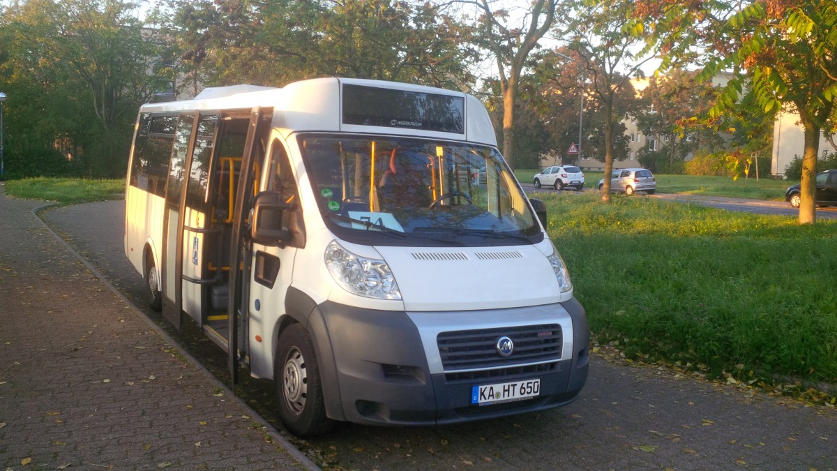 Merkavim Kleinbus auf Fiat Ducato Basis der Firma Hagro Transbus GmbH in Karlsruhe an der S-Bahn Haltestelle August Bebel Straße. Der Sonnenaufgang verspricht einen goldenen Oktobertag im Jahre 2014. 