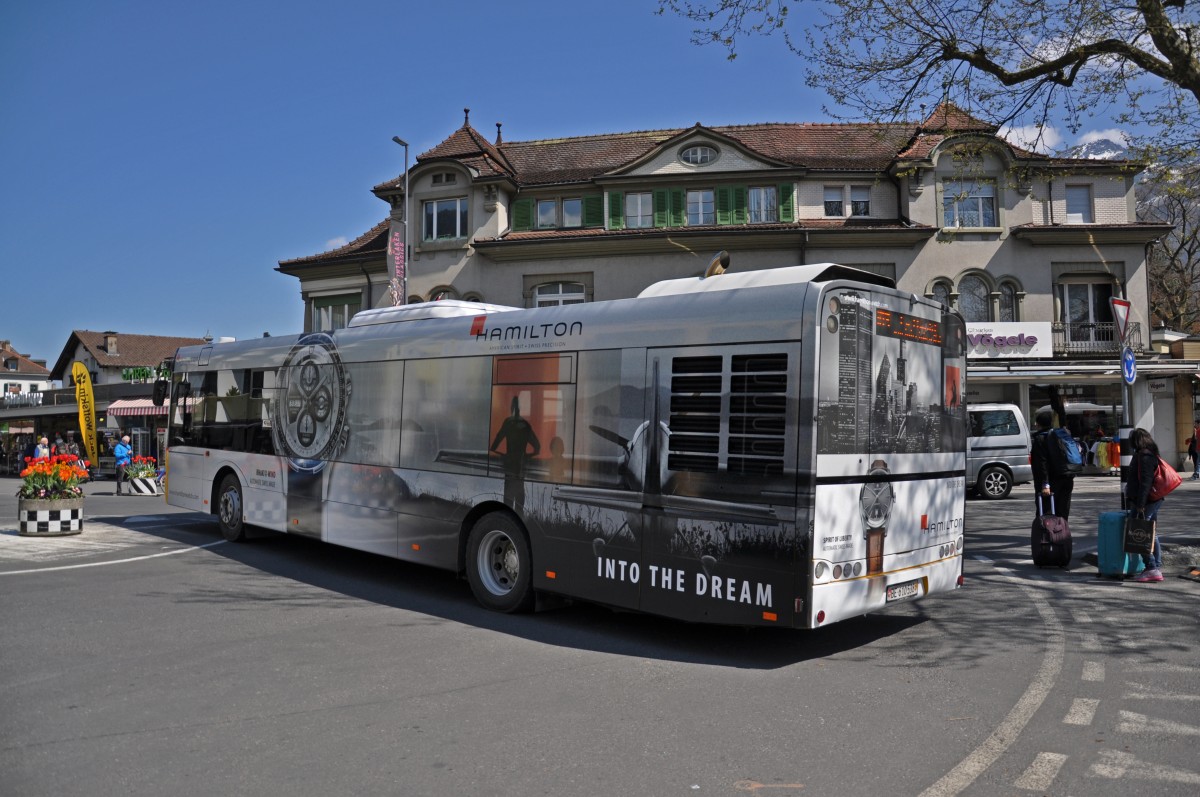 Solaris Bus der Post mit einer Uhren Werbung von Hamilton beim Bahnhof Interlaken West. Die Aufnahme stammt vom 16.04.2014.