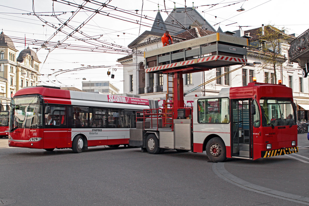 Solaris Trollino 18 Nr. 180 von Stadtbus Winterthur trifft am 22. April 2016 auf dem Bahnhofplatz auf den Turmwagen. Dieser ist seit 1997 im Einsatz und verfügt ebenfalls über eine Buskabine.