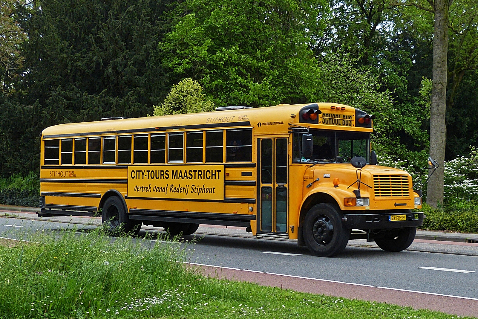 Oldtimer US Schulbus International 3500 auf Stadt Rundfahrt durch Maastricht unterwegs. 05.2023