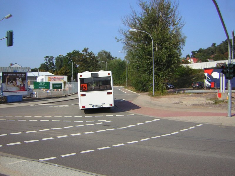 Ein Mercedes Bus lterer Generation steuert den Parkplatz fr Stadtbusse am Rmerkastell an.