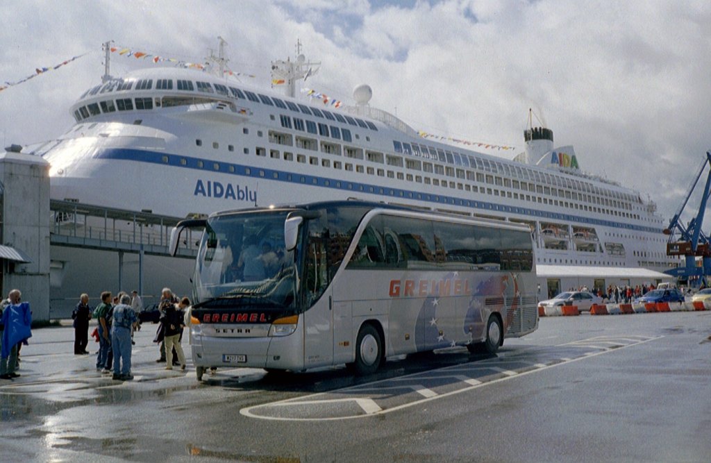  Der Setra S 415 HD der Fa. Greimel-Reisen vor der Kulisse des Kreuzfahrerschiffes AIDAblu am Schwedenkai in Kiel.