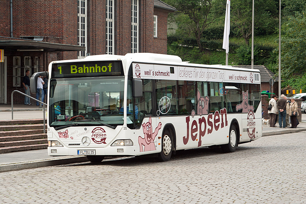 Am Flensburger Bundesbahnhof stand am 3. Juli 2007 der FL-BU 35 von Aktiv-Bus nach der Ankunft auf der Linie 1. Ob die Schweine auf der Werbung sich wirklich so auf dem Schlachter freuen, wenn sie zu Wurst und Koteletts verarbeiten werden?