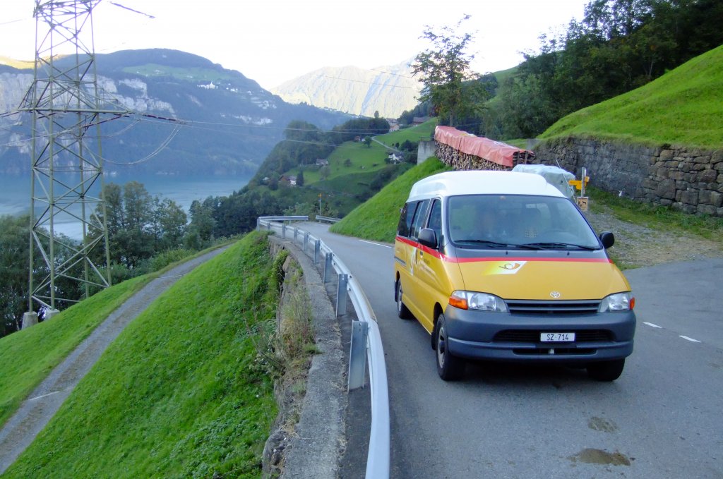 Das kleinste PostAuto der Zentralschweiz: Wagen SZ 714 von PU Gisler aus Riemenstalden, ein Toyota Hiace aus 2000, fährt zwei mal Täglich den Kurs von Riemendtalden zum SBB-Bahnhof Sisikon. Am 11.9.2010 entstand bei der Binzenegg diese Aufnahme auf Bergfahrt hoch über dem Urnersee. 