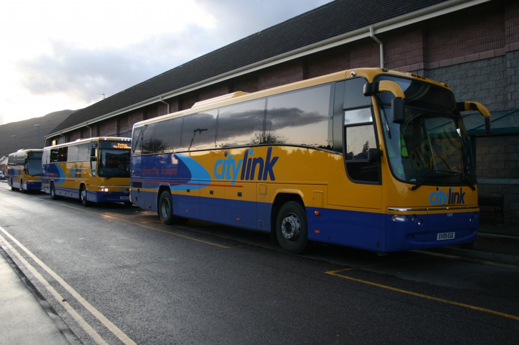 Drei Volvo-Plaxton-Wagen aus 2009 stehen am 6.10.2009 abends beim Bahnhof Fort William. Gleich mehrere CityLink-Linien beginnen und enden hier, weshalb hier vor allem abends diverse der gelb-blauen Wagen zu sehen sind. Nebst zwei B12B ist dazwischen auch ein etwas kleinerer B7R abgestellt. 