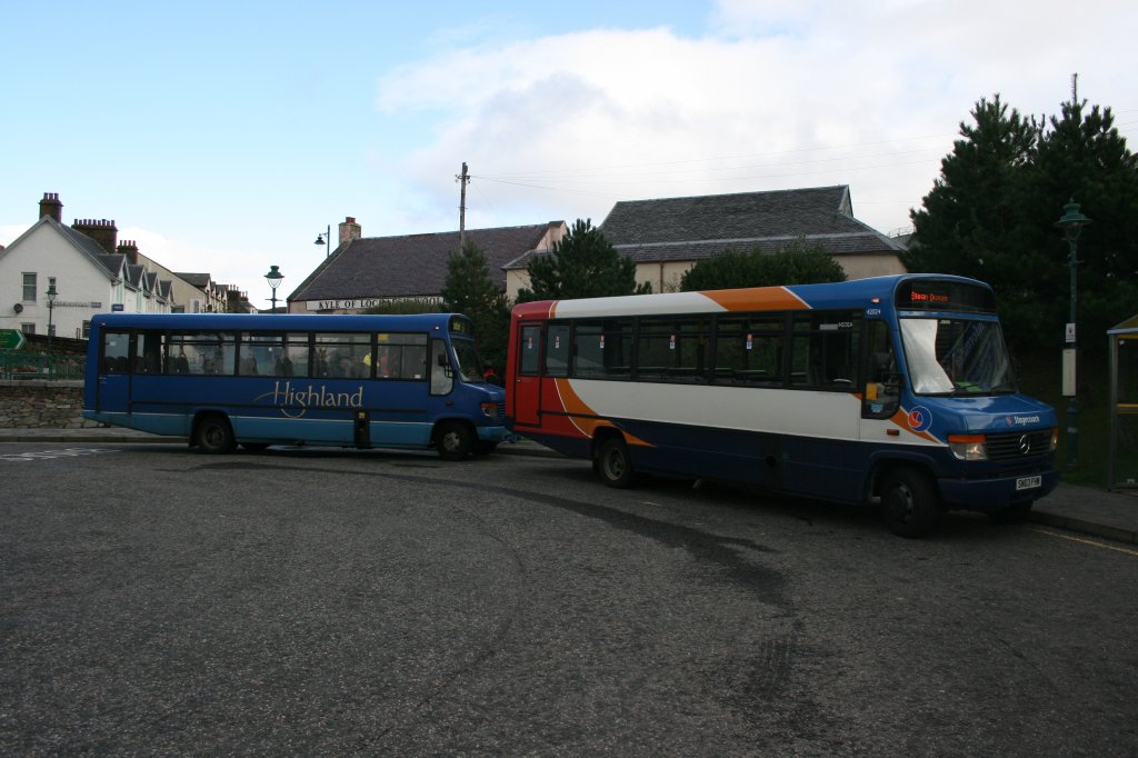Je weiter nrdlich man in Grossbritannien geht, desto hufiger werden die kleinen Mercedes-Vehikel auf Nebenlinien. Bei der Busstation in Kyle of Lochals wartetem Mittags am 6.10.2009 gleich zwei solche Wagen auf die Abfahrt: Vorne der SN03FHM (MB/Plaxton O814D, 2003) von Stagecoach-Subunternehmer Tait aus Irvine und hinten der S751SCJ von Subunternehmer Perry aus Bromyard (MB/Plaxton O814D, 1998)