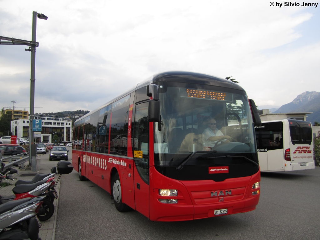 Postauto/Regie Chur Nr. 94 ''Bernina Express'' (MAN Lion's Regio R12) am 24.8.2012 beim Bhf. Lugano. Nach der erfolgten Reise Lugano - Tirano - Lugano fhrt der BEX-Bus nun zur Garage von PU Malcantone, der in der Sommersaison den Chauffeur sowie die Unterkunft des Wagens stellt.