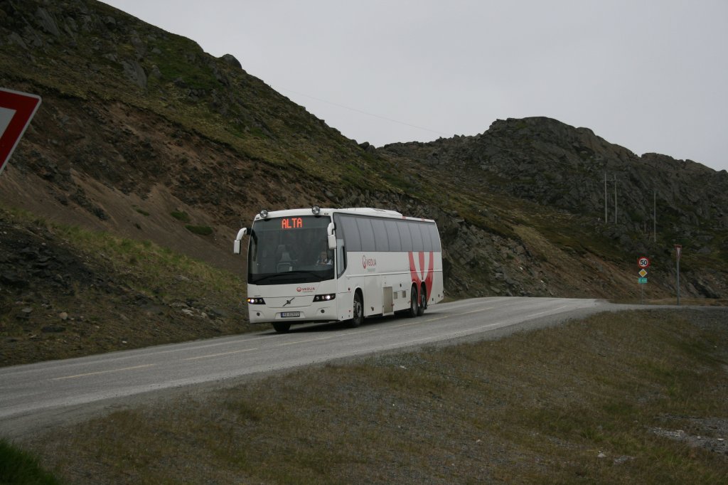 Zwischen Alta, Endpunkt des Norwegischen Schnellbusnetzes, und Honningsvåg verkehren zwei tägliche Buskurse von Veolia/FFR. Das Kurspaar ab Honningsvåg wird in der Regel von diesem brandneuen Volvo-9700-Dreiachser gefahren, so auch am 22.6.2010, aufgenommen auf der E6 wenig ausserhalb des Ortes. 