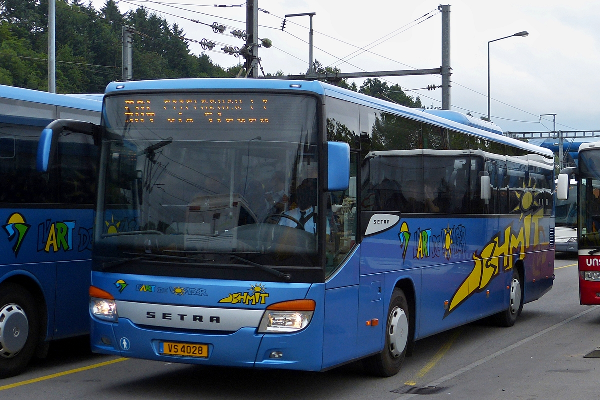 . VS 4028, Setra S 415 UL von Voyages Schmit, fährt zwischen den abgestellten Bussen zur Bushaltestelle am Bahnhof in Ettelbrück.  Julli 2015