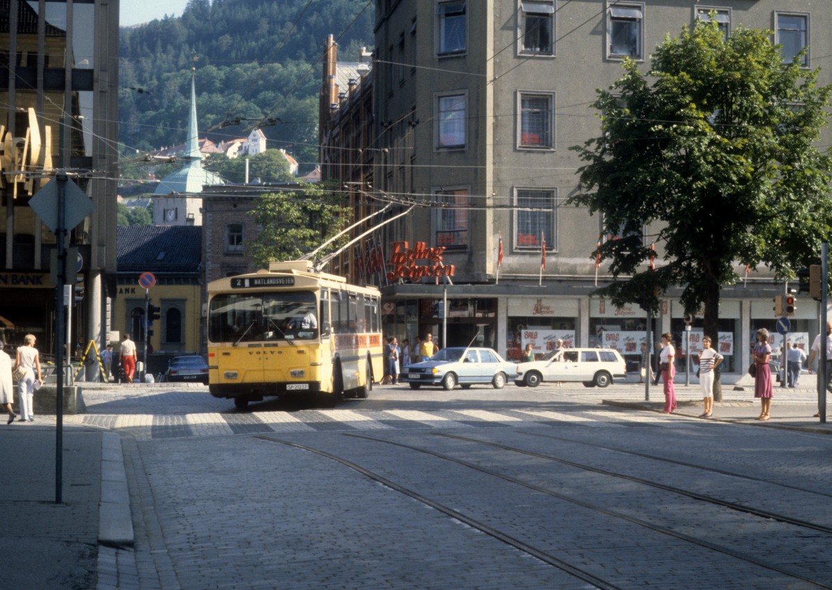 Bergen Bergen Sporvei Trolleybuslinie 2 im August 1982. - Bis zum Dezember 1965 fuhren Strassenbahnen in Bergen - deshalb der Name Bergen Sporvei (: Strassenbahn Bergen). Auf dem Foto sieht man einen Rest des Schienennetzes. - Seit dem 22. Juni 2010 fährt in Bergen eine moderne Stadtbahn, Bybanen. - 1982 gab es noch zwei Obuslinien in Bergen. z.Z. gibt es nur die Linie 2, deren Zukunft unsicher ist. 