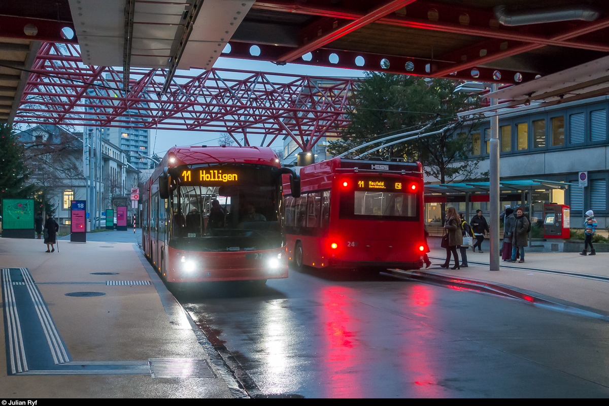 Die neuen BERNMOBIL Trolleybusse 24 und 27 begegnen sich am 22. Dezember 2017 an der Haltestelle Inselspital der Linie 11. Wegen der sehr niedrigen Fussgängerbrücke, werden die Oberleitungen hier seitlich vom Bus über dem Trottoir geführt. Die Haltestelle ist - bislang in Bern immer noch ein Sonderfall - mit einem Kasseler Sonderbord Plus für stufenloses Ein- und Aussteigen ausgerüstet.