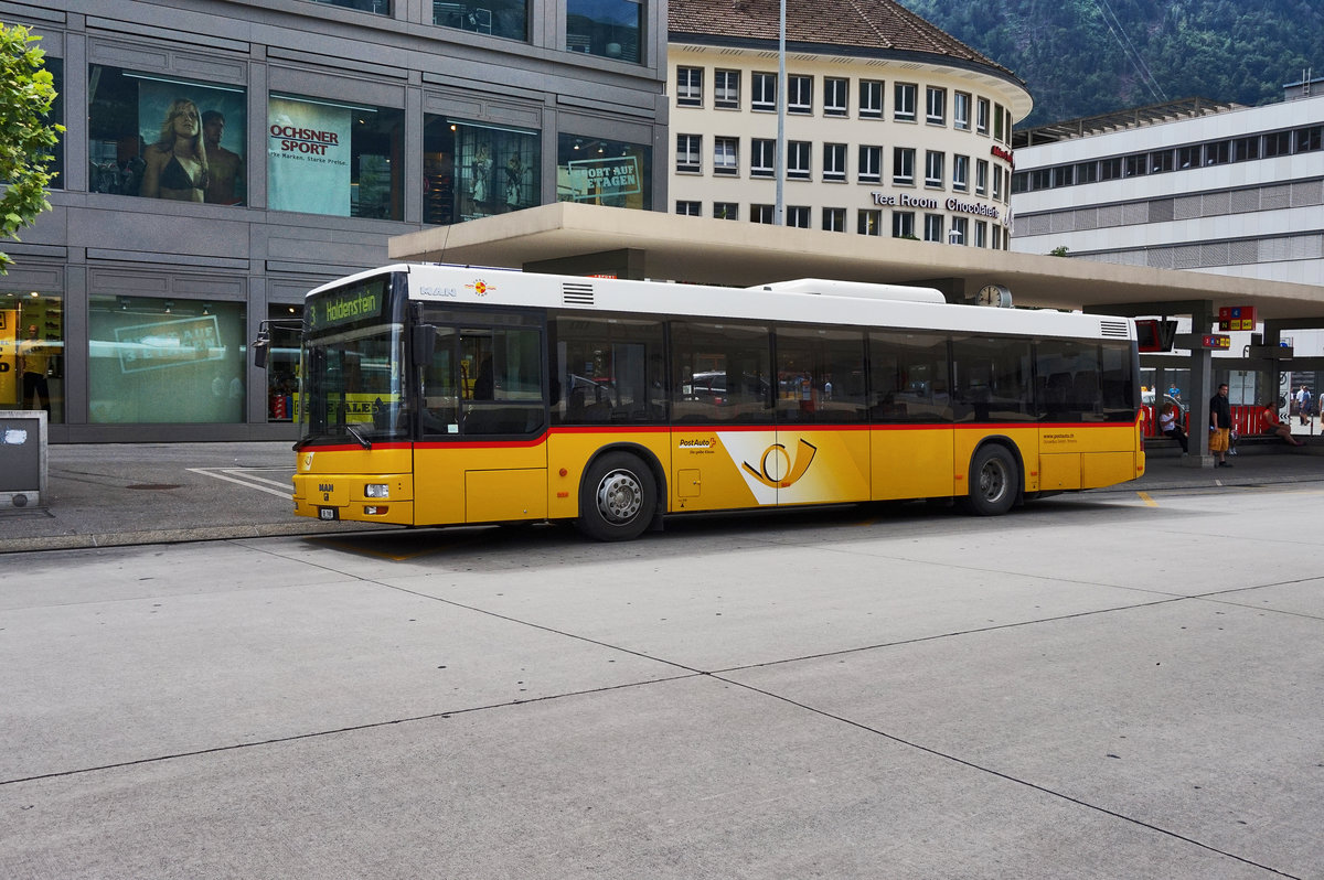 Ein MAN-Bus von PostAuto, hält an der Haltestelle Chur, Bahnhofplatz.
Aufgenommen am 21.7.2016.