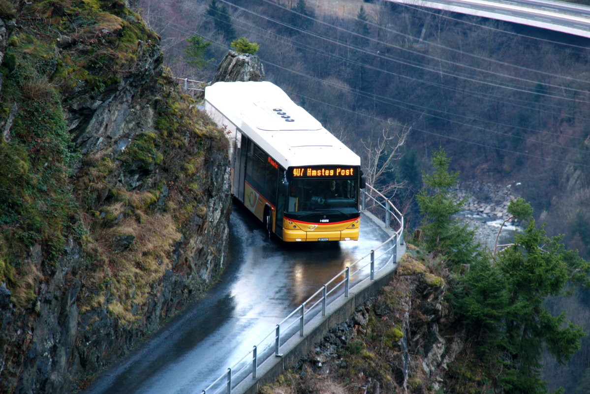Ein Scania/Hess K320 UB Postauto auf dem Kurs 60.407 Golzern Seilbahn - Bristen - Amsteg oberhalb der Maderanerschlucht; 10.01.2015