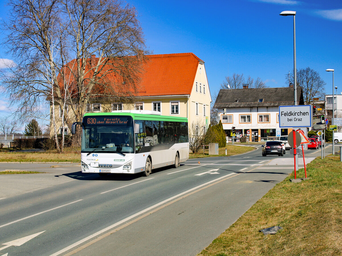 Feldkirchen. Am 11.03.2023 fährt der Postbus BD 14813 auf der Linie 630 zwischen Graz und Fernitz. Das Foto entstand zwischen den Haltestellen Feldkirchen Gemeindeamt und Flughafen Graz GRZ.