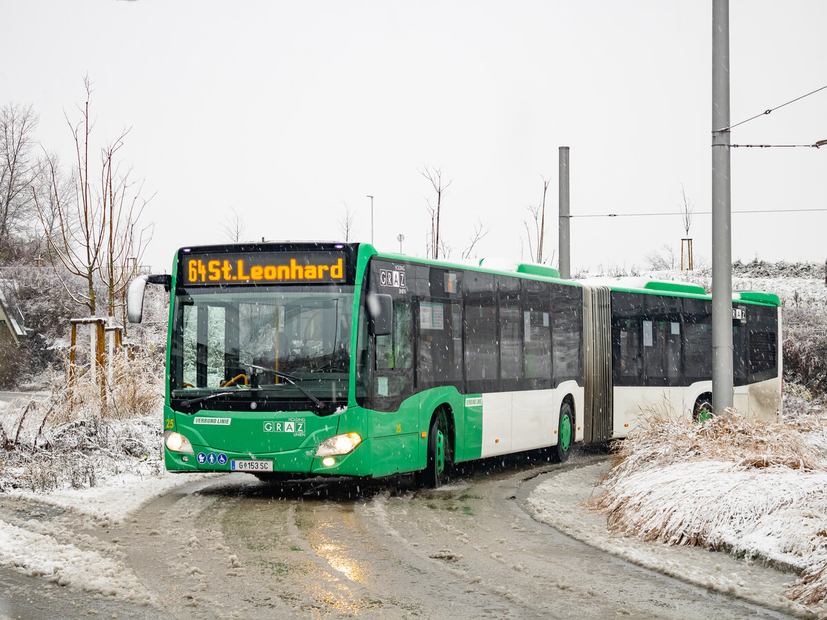 Graz. Am Vormittag des 02.12.2023 hat es in der steirischen Hauptstadt ordentlich geschneit – Wagen 25 der Graz Linien ist hier als Linie 64 beim Verlassen der Haltestelle Puntigam zu sehen.
