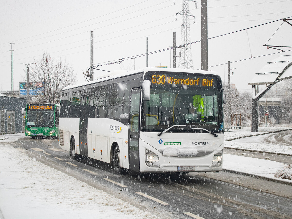 Graz. Am Vormittag des 02.12.2023 hat es in der steirischen Hauptstadt ordentlich geschneit – Wagen 14708 von Postbus ist hier als Linie 630 beim Verlassen der Haltestelle Puntigam zu sehen.