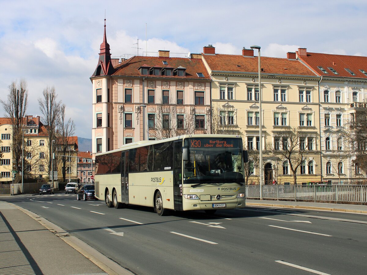 Graz. Der Postbus BD 14227 war am 03.03.2023 auf der Linie X30 von Graz nach Hartberg unterwegs, hier auf der Augartenbrücke.