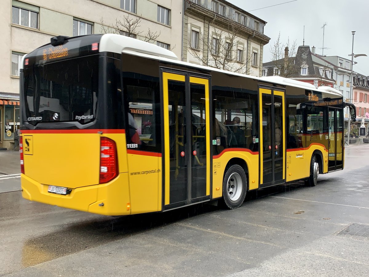 Heckansicht des MB C2 K hybrid '11331' von PostAuto am 16.3.21 bei der Abfahrt in Delemont.