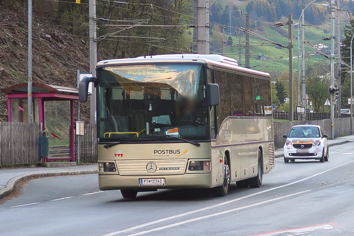 Mercedes Integro von Postbus PT-12242 noch in Sandquarz-Lackierung fährt in Landeck an der Haltestelle Landeck Perjener Brücke vorbei. Aufgenommen 17.4.2018.