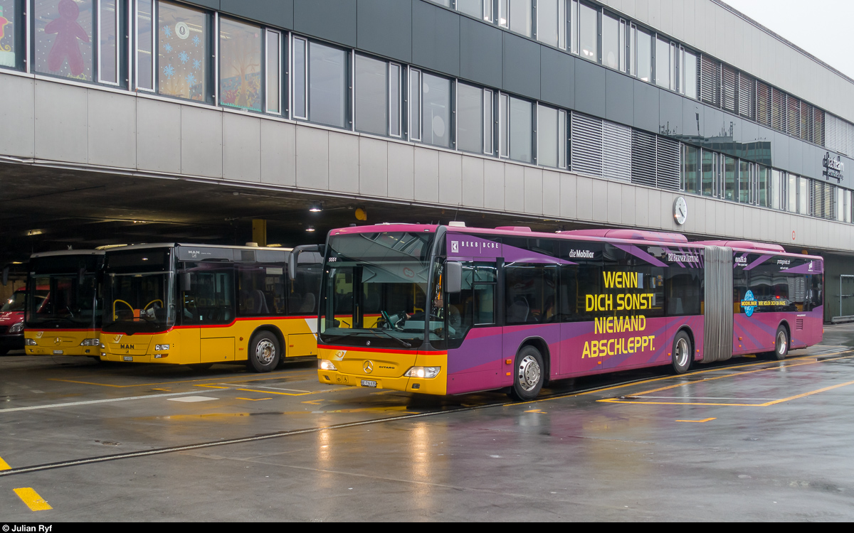 Postauto Gelenkbus 5551 mit Werbung für die Nachtliniengesellschaft am 22. Dezember 2017 auf dem Postautodeck über dem Berner Hauptbahnhof.