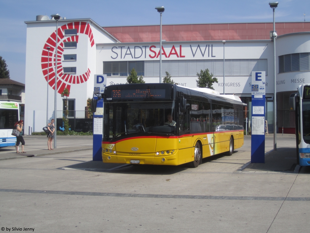 Postauto/PU Schmidt (ex. Regie Yverdon-les-Bains) SG 397 506 (Solaris Urbino 12) am 6.8.2018 beim Bhf. Wil SG. Die frührere Herkunft dieses Postautos ist immer noch am Waadtländer, statt dem St.Galler Wappen unterhalb des Fahrerfensters zu sehen.