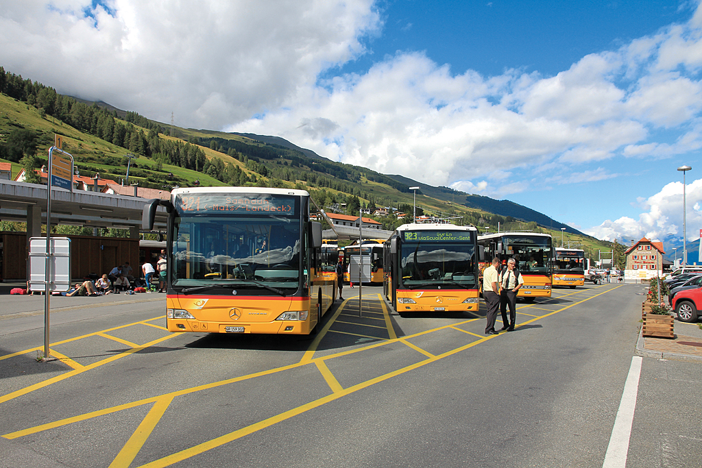Postbusse der Marken Mercedes und Setra warten auf Gäste am Bahnhof in Scuol. Aufnahme vom 02. Aug. 2015, 15:37
