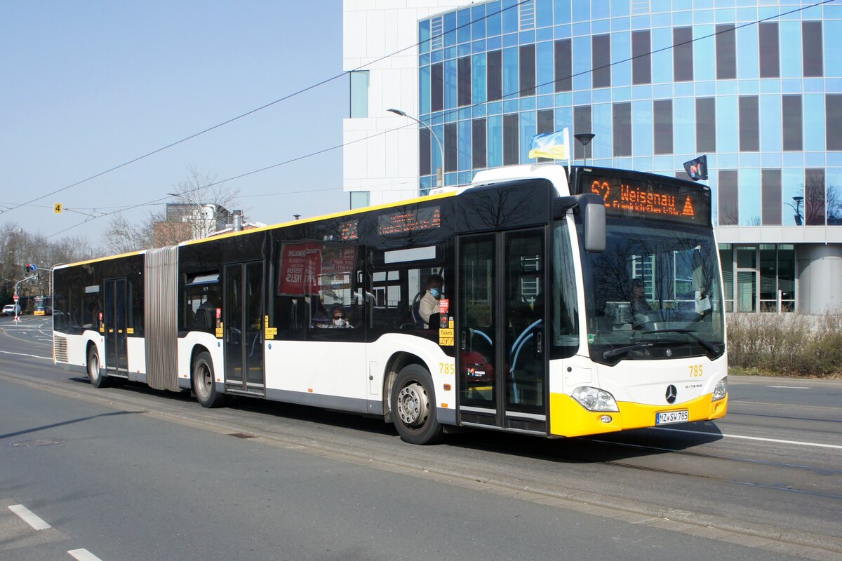 Stadtbus Mainz: Mercedes-Benz Citaro C2 Gelenkbus der MVG Mainz / Mainzer Verkehrsgesellschaft (Wagen 785 / Beflaggung: Ukraine / Friedenstaube), aufgenommen im März 2022 in der Nähe der Haltestelle  Bismarckplatz  in Mainz.