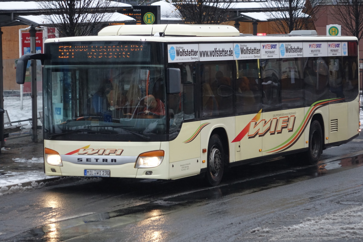 WIFI-Bustouristik (Wiessmann & Fischer KG) / MIL-WI 230 / Aschaffenburg, Luitpoldstr. (Hst Stadthalle) / Setra S 415 NF / Aufnahemdatum: 01.12.2020 / Werbung: INTERSPORT Wolfstetter, Schuhhaus Wolfstetter (Dachkante)