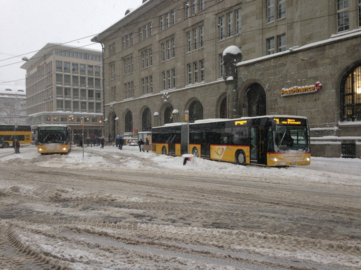 Wintereinbruch in St. Gallen: Postauto Citaro I G und Citaro II G auf dem Bahnhofplatz, 30.12.2014.

