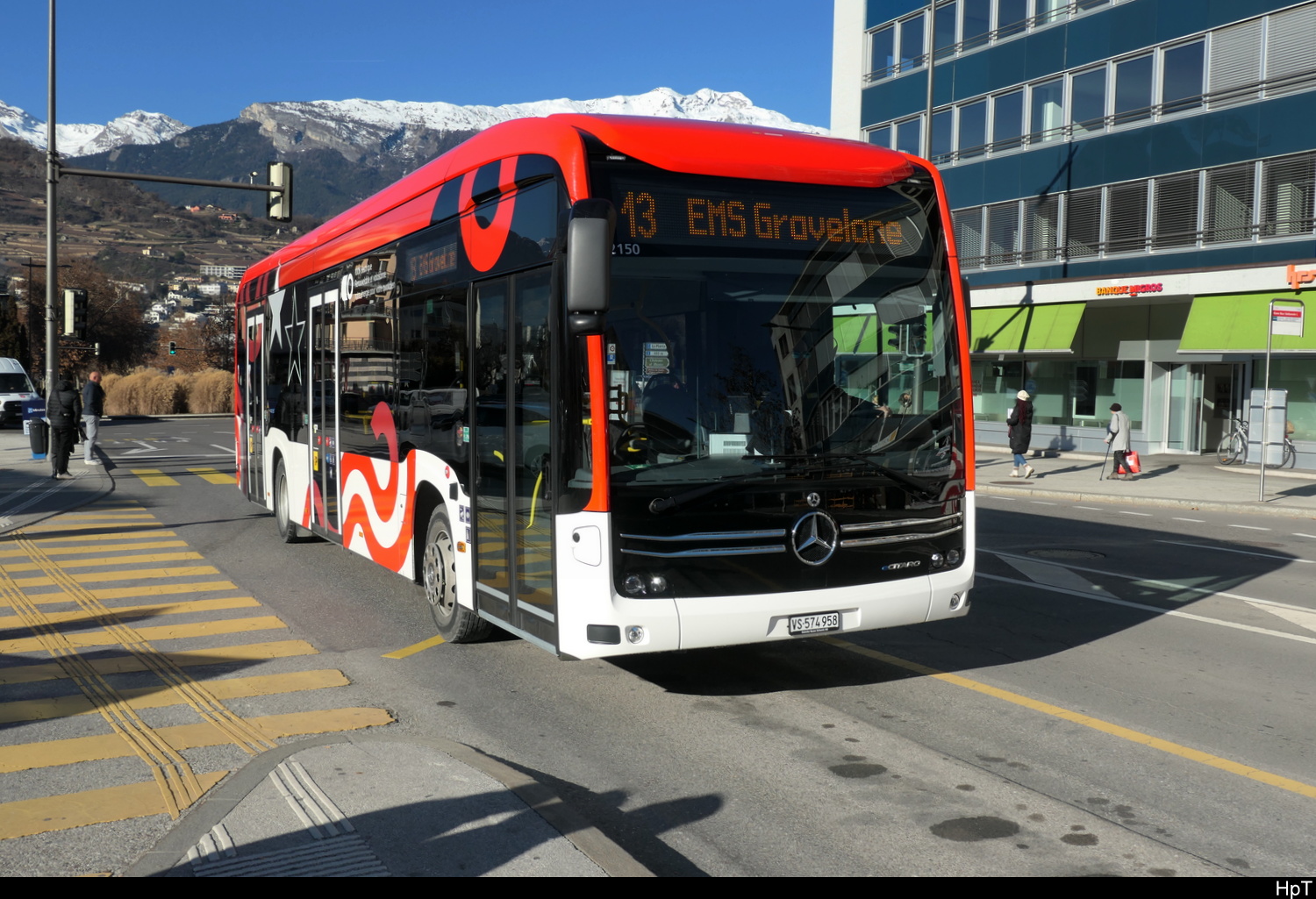 Postauto / Ortsbus Sion - Mercedes e Citaro  VS  574958 bei der Zufahrt zu den Bushaltestellen vor dem Bahnhof in Sion am 29.12.2025
