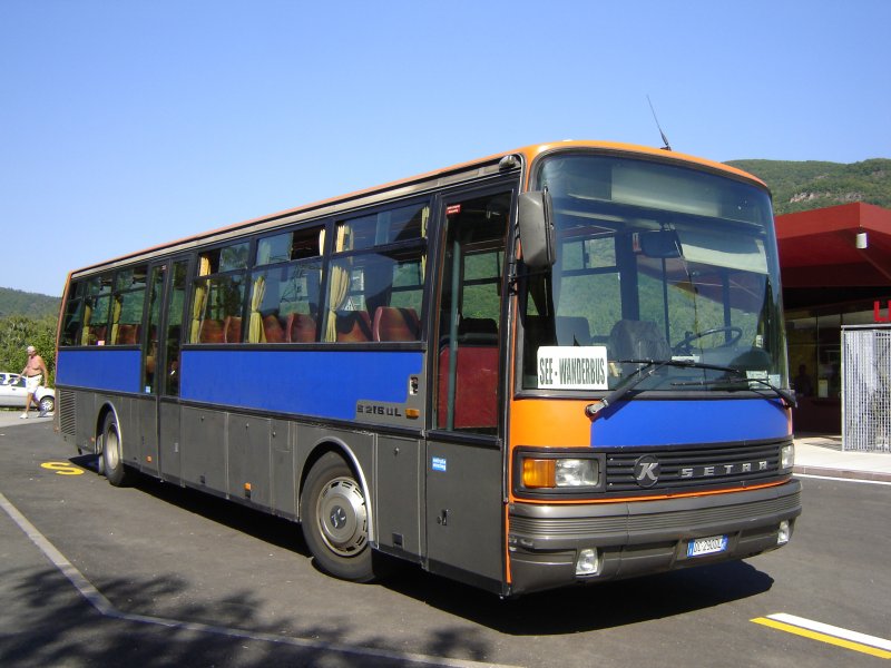 Setra S 215 UL von Rauch Reisen. Der Bus wurde vom SAD bernommen und als See & Wanderbus Kaltern im Touristenverkehr eingesetzt. Gut zu erkennen ist noch die ehemalige orangene Farbe auf der Frontseite, die wie die silberne Seite mit blauer Folie berklebt wurde. Darunter befanden sich die SAD-Logos. Bild wurde im September 2006 aufgenommen.