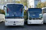 Ein neuer MB Tourismo und ein Weisser C2 K mit PostAuto Inneneinrichtung, am 13.10.18 bei Evobus in Kloten parkiert.