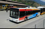 Postauto / Ortsbus Brig - MAN Lion`s City  VS 449119 abgestellt auf einem Parkplatz in Brig am 29.07.2026  .. Standort des Fotografen in einem Fahrendem Zug der MGB