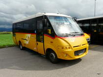 Postauto - Kleinbus Cacciamali  JU 65412 abgestellt auf einem Parkplatz etwas ausserhalb von Delemont am 08.09.2013