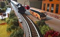 Ein Mercedes-Benz O 404 von Rietze (Mercedes Werbe-Sondermodell) fhrt in Begleitung eines D-Zuges stadtauswrts.