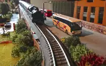 Ein Mercedes-Benz O 404 von Rietze (Mercedes Werbe-Sondermodell) f�hrt in Begleitung eines D-Zuges stadtausw�rts.