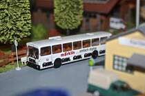 Ein Mercedes-Benz O 305 von Brekina befindet sich an einer Bushaltestelle. Es handelt sich hierbei um ein Messe-Sondermodell.