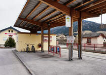 Blick auf die Bushaltestelle Mittersill Bahnhof. Da Mittersill nicht nur in den SVV sondern auch in den VVT integriert ist, ist das Haltestellenschild hier nach den neuen Normen des VVT gestaltet.