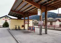 Blick auf die Bushaltestelle Mittersill Bahnhof. Da Mittersill nicht nur in den SVV sondern auch in den VVT integriert ist, ist das Haltestellenschild hier nach den neuen Normen des VVT gestaltet.