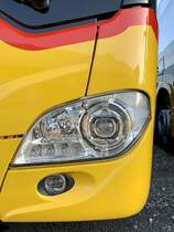 Detailansicht auf den Frontscheinwerfer eines MB C2 hybrid für PostAuto am 23.11.20 bei Evobus Winterthur.